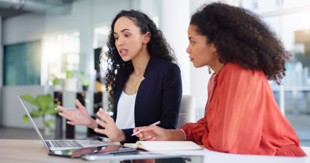 Coaching, training and woman with mentor writing, learning and taking notes in office. Laptop, teaching and manager talking, explain and helping intern with notebook, project and business report.の写真素材