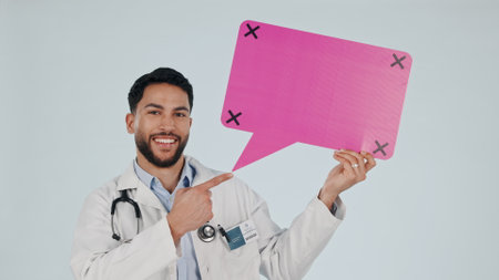 Man, doctor and speech bubble mockup, presentation or healthcare chat, FAQ and health advice in studio. Face, quote and medical worker pointing to poster ideas and tracking marker on white backgroundの写真素材