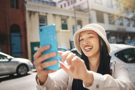 Happy woman on street with phone, live streaming in city and travel holiday blog for social media post. Influencer, streamer or gen z girl with urban fashion, smartphone and smile in content creationの写真素材