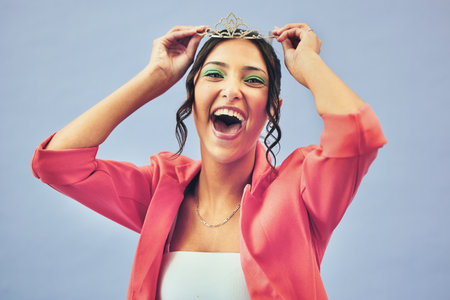 Fashion, excited and portrait of woman with crown in studio for glamour, luxury and winning prize. Beauty, wow and person with tiara for princess pageant, winner and cosmetics on purple backgroundの写真素材