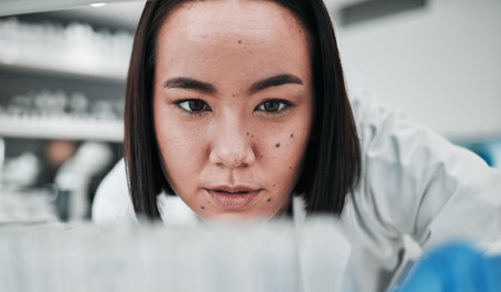 Test tubes, scientist and woman with doctor investigation, thinking and science research. Laboratory, medical professional and healthcare worker with medicine and liquid check for hospital testの写真素材