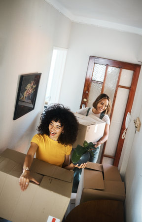 Boxes, homeowner and couple with love, lesbian or moving with real estate, achievement or excited. Queer people, happy women or girls with marriage, goals or new apartment with happiness or propertyの写真素材