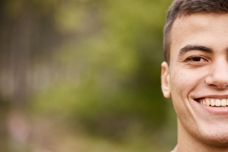 Smile, half portrait and a man in nature for fitness, exercise or a workout on bokeh. Happy, face and an athlete or person in a park for training, sport or running on mockup space for cardioの写真素材