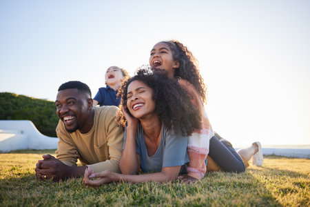 Grass, funny and family relax on vacation, bonding and having fun together on mockup space. Children, laughing and interracial parents in nature to travel on holiday, care and love outdoor at gardenの写真素材