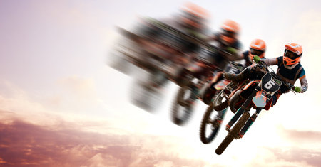 Motorcycle, double exposure and motion blur with a sports person in the air during a jump at a race course. Bike, training and energy with an athlete on a cloudy sky for speed, power or freedomの写真素材