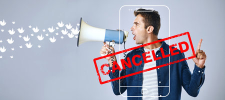 Cancel culture, opinion and social media with man and megaphone for online, cyberbullying and toxic message. Free speech, censorship and anger with person on grey background for banner and voiceの写真素材