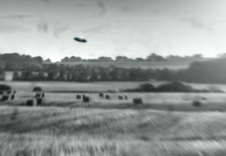 Alien, spaceship and UFO on farm, nature or sky with fantasy or science fiction event in countryside, field or landscape. Earth, aliens and extraterrestrial drone in environment with blur or motionの写真素材