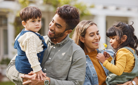 Mother, father and happy outdoor with children and a flower in spring with love, care and security. A man, woman and kids or young family in a backyard to relax while bonding on holiday or vacationの写真素材