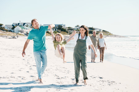 Walking, adventure and family generations on a beach together on vacation, holiday or weekend trip. Happy, travel and child with parents and grandparents bonding by ocean or sea in Australia.の写真素材