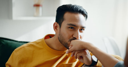 Hand, kiss and couple on a sofa, relax and bond with conversation, romance and care at home. Holding hands, love and happy man in a living room with trust, support and smile while speaking in a houseの写真素材