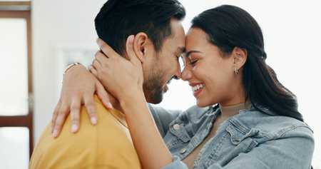 Couple, forehead touch and hug in living room with love, bonding and happy people together at home....