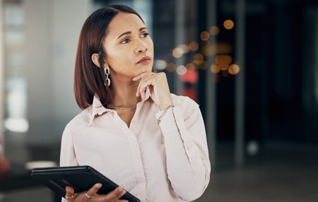 Woman in office thinking with tablet, night and ideas for HR schedule and online feedback in overtime. Internet, networking and digital insight, businesswoman in late work at human resources agency.の写真素材
