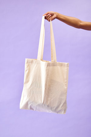 Sustainability, shopping and eco friendly bag by person or recycling customer isolated in a studio purple background. Environment, retail and woman with carbon footprint, zero waste and groceryの写真素材
