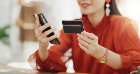 Happy woman, credit card and phone for business online shopping, trading or fintech payment in office startup. Asian fashion person with bank information on cellphone for website loan or transactionの写真素材