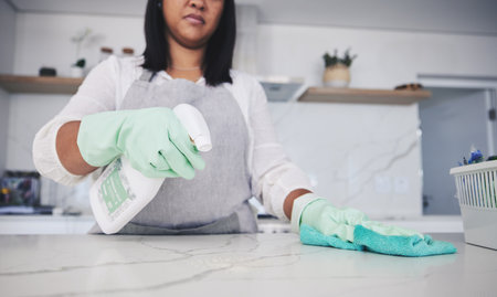 Woman, hands and cleaning kitchen table with spray bottle, detergent or bacteria or germ removal at home. Female person, maid or cleaner wiping surface with cloth in clean hygiene or sanitize houseの写真素材