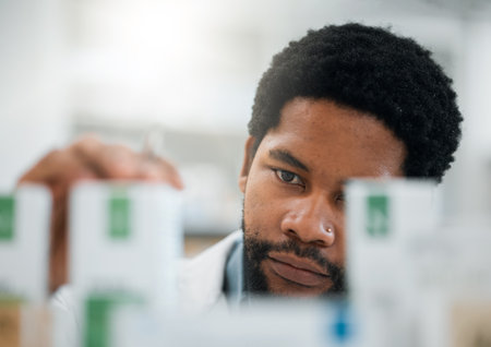 Black man, pharmacist, drugs and health with medicine, prescription and organize stock in pharmacy. Pills, inventory with healthcare and African medical worker, hospital dispensary and pharmaceuticalの写真素材