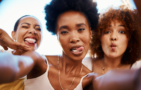 Funny selfie, portrait and friends in a house for bonding, social media or happy together. Diversity, home and face of crazy women taking a picture for memory with tongue out, comedy and smileの写真素材