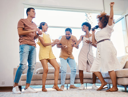 Karaoke, party and friends dancing in the living room with a microphone to music, playlist or radio....