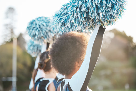 Cheerleader team, sports and women dance on field for performance, motivation and support for game. Teamwork, dancer and people in costume cheer for match, competition and sporting event outdoorsの写真素材
