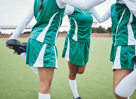 Team, stretching legs and warm up on field, sports and uniform for match, balance and teamwork together. Diverse group of athletes, outdoor and exercise to prepare for game, workout for performanceの写真素材