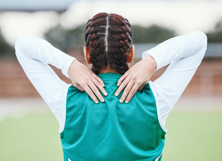 Athlete, field or sports woman with back pain in exercise, body training injury or outdoor workout. Girl, stress or injured female hockey player with burnout, accident or muscle problem emergencyの写真素材