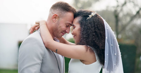 Wedding, couple and love dancing outdoor together, happy and celebration for care and commitment. Marriage, man and woman moving with eyes closed, bride and groom embrace for first dance in natureの写真素材