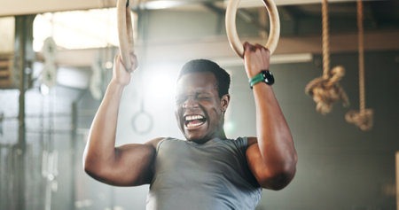 Gym, intense gymnastics and black man doing pull up exercise, arm muscle building or bodybuilding for strength training. Determined, athlete and African person doing fitness, challenge or workoutの写真素材