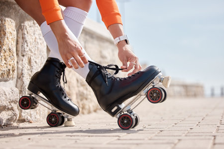 Tie, shoes and hands of woman with roller skates outdoor for exercise, workout or training with wheels on sidewalk. Fun, sport and person start fitness with rollerskating and cardio in summerの写真素材