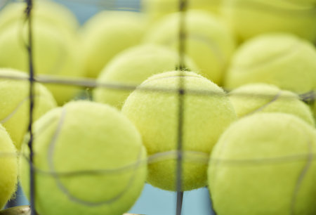 Tennis ball, close up and basket for training or sport for exercise, cardio or serve for game. Sports equipment, tournament and turf for professional athlete or health for outdoor workout or fitnessの写真素材