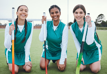 Portrait, smile and hockey with a woman team outdoor on a field for sports, a game or competition together. Fitness, exercise and diversity with a happy young athlete group on an astro turf courtの写真素材