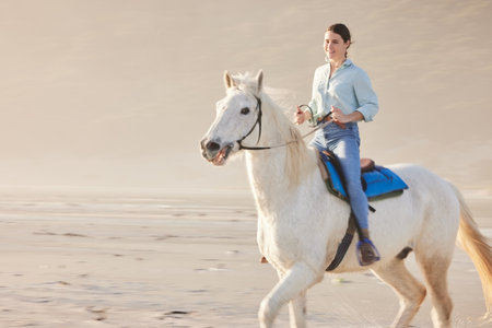 Horse riding, mockup and woman on outdoor with animal as jockey for happiness, joy and sand as hobby. Equestrian, smile and happy person or rider with sport on vacation or nature holiday with peaceの写真素材