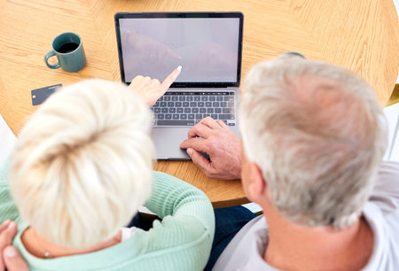 Laptop, top view and senior couple at table for online shopping, reading email and point at mockup...