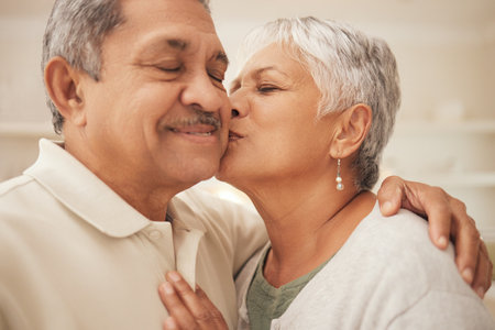 Selfie, kiss and senior couple in home with love, support and portrait of marriage in retirement together. Digital photography, face of happy man and old woman in apartment to post on social media.の写真素材