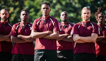 Team, men and field for athlete in portrait with arms folded, united and determined with mindset to win. Diverse group, players and together with intense, rugby sports and face for victory in gameの写真素材