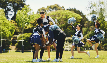 Team, cheerleader or girl on field for practice or fitness training in outdoor workout or performance. Learning routine, dance or sports woman in group for motivation, inspiration or support on grassの写真素材