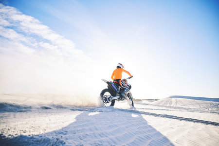 Desert, back and man on motorbike outdoor to race, adventure or travel for extreme sport on mockup space. Off road, sand and driver on motorcycle on dirt in nature for action, competition and freedomの写真素材