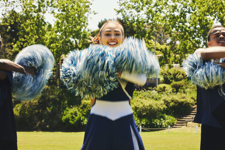 Cheerleader, dancing and field in teamwork in sport, fitness and energy at competition in team. Woman, men and diversity in balance for training, pom poms and college performance with collaborationの写真素材