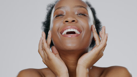 Black woman, portrait and beauty with skincare, facial with natural cosmetics on white background. Face, dermatology and African model with smile, moisturizer and treatment for skin glow in studioの写真素材