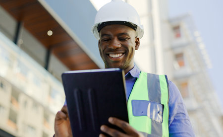 Black man in construction, tablet and architect working on floor plan, inspection and maintenance job outdoor. Check digital blueprint for architecture project, design software and quality assuranceの写真素材