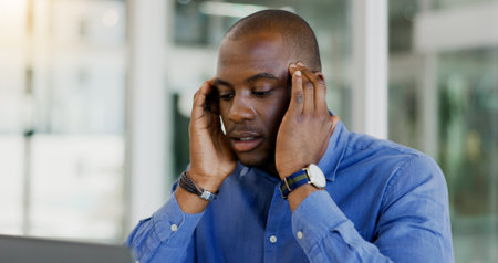 Businessman, stress and headache in office, burnout and anxiety for problem, issue and profession. Black person, frustrated and worry for deadline, mistake and pressure or overwhelmed or overworkedの写真素材