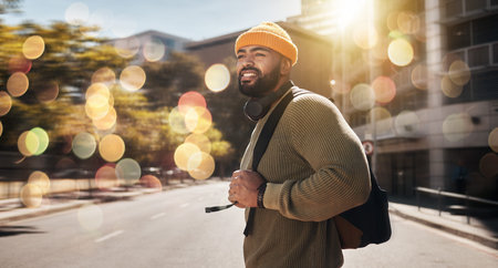 City, travel and man with banner, walking and travel with student, fashion and casual outfit. Person, stylish and guy on the road, outdoor and bokeh with a cap, trendy and hipster with stylish outfitの写真素材
