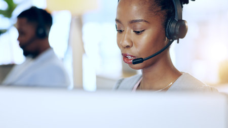 Call center, computer and black woman talk for telemarketing, support or contact us at help desk in office. Customer service, sales agent and African consultant in communication, crm and businessの写真素材