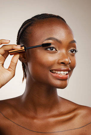 Mascara, happy woman and makeup in studio for beauty, cosmetics and smile on brown background....