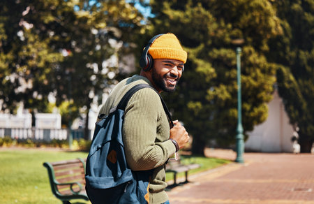 Portrait, outdoor and man with headphones, streaming music and connection with radio, sunshine and...
