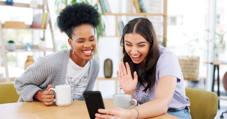 Girl friends, video call and phone in coffee shop, wave and excited for conversation, talk and...