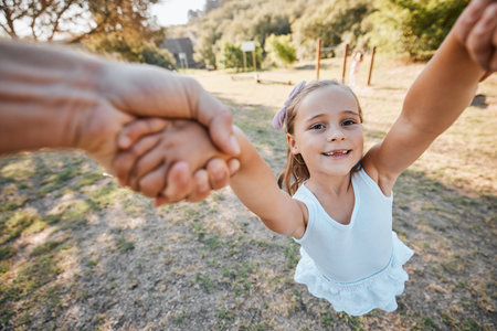 Happy, pov and hands swing child outdoor in garden, park or game in nature with parent. Girl, face and dad or mom swinging kid for crazy, fun or bonding in summer, vacation or backyard gamesの写真素材