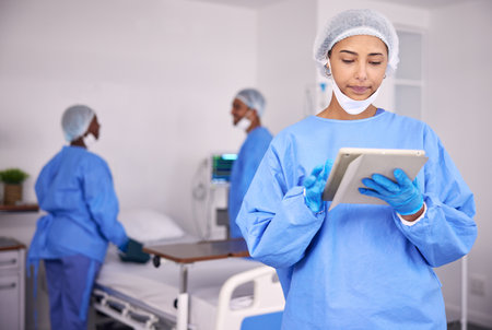 Woman, doctor and tablet in research at hospital for communication, Telehealth or networking at hospital. Female person, medical nurse or professional surgeon with technology for schedule at clinicの写真素材