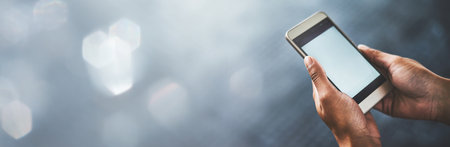 Person, hands and phone screen on mockup for social media, communication or networking on banner. Closeup of user with mobile smartphone app, display or advertising technology on bokeh backgroundの写真素材