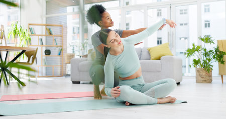 Personal trainer, yoga and women in living room stretching for wellness, healthy body and fitness on floor. Friends, home and people on gym mat for pilates, exercise and support for balance or muscleの写真素材