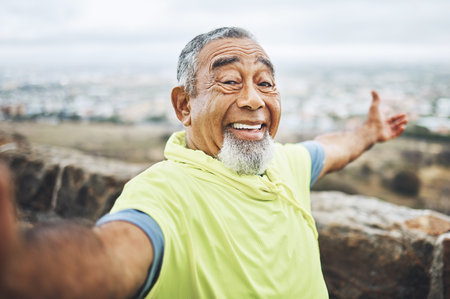 Selfie, happy and senior man hiking for health, wellness or cardio training on a mountain. Smile, nature and portrait of excited elderly male person taking a picture for outdoor trekking in woods.の写真素材